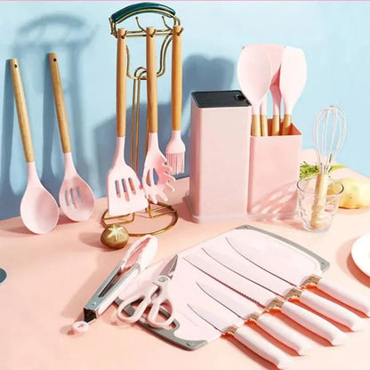 Set de utensilios de cocina rosa con mango de madera, incluye cuchillos, cucharas y batidor organizados