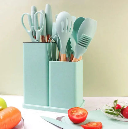 Utensilios de cocina verdes menta en soporte, rodeados de verduras frescas y tomate cortado