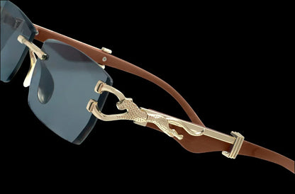 Gafas de sol con lentes oscuras y patillas de cuero marrón, detalle de pantera dorada decorativa